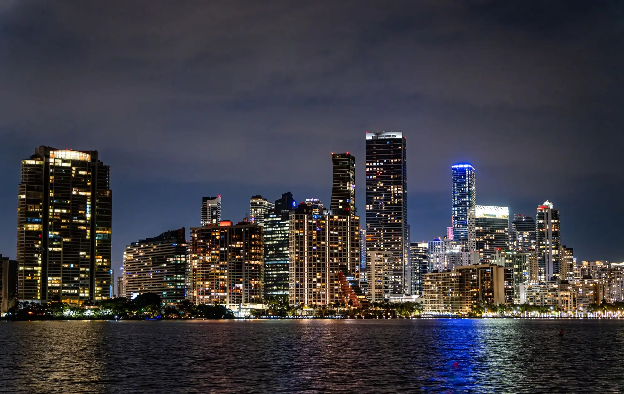 Miami skyline lit up at night across Biscayne Bay