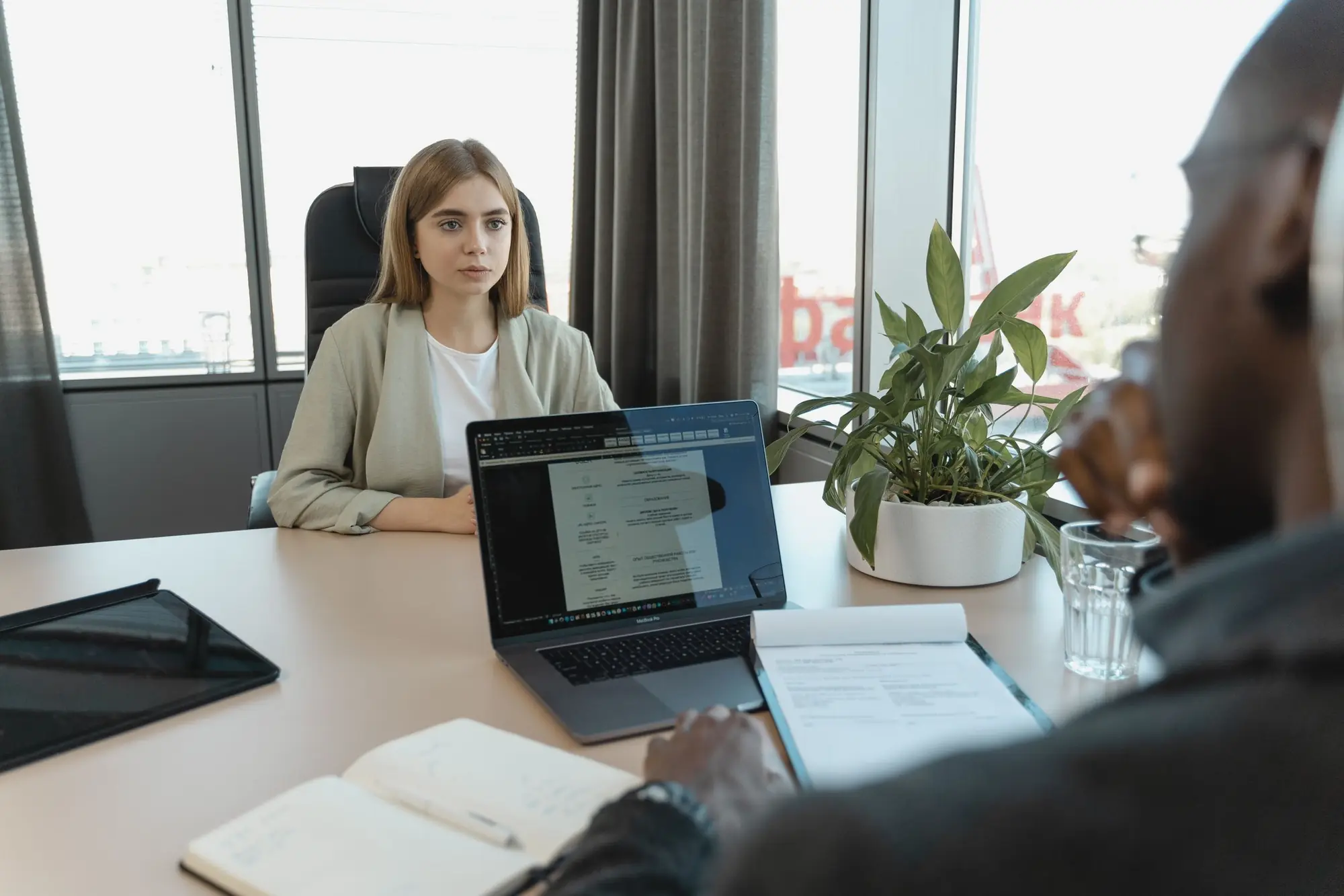 Recruiter interviewing a candidate across a desk in a modern office