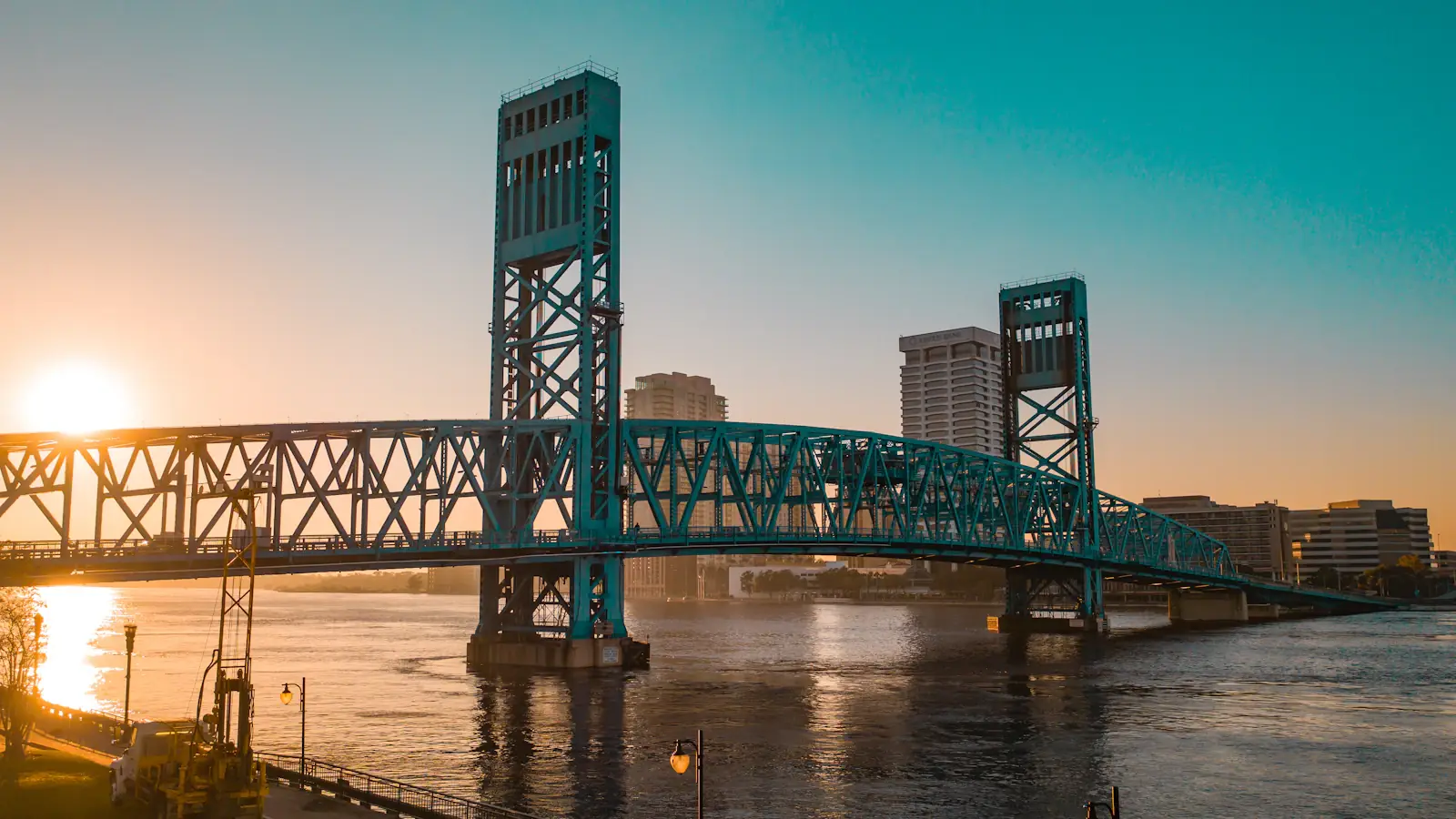 Green steel bridge spanning the river in Jacksonville on a clear day