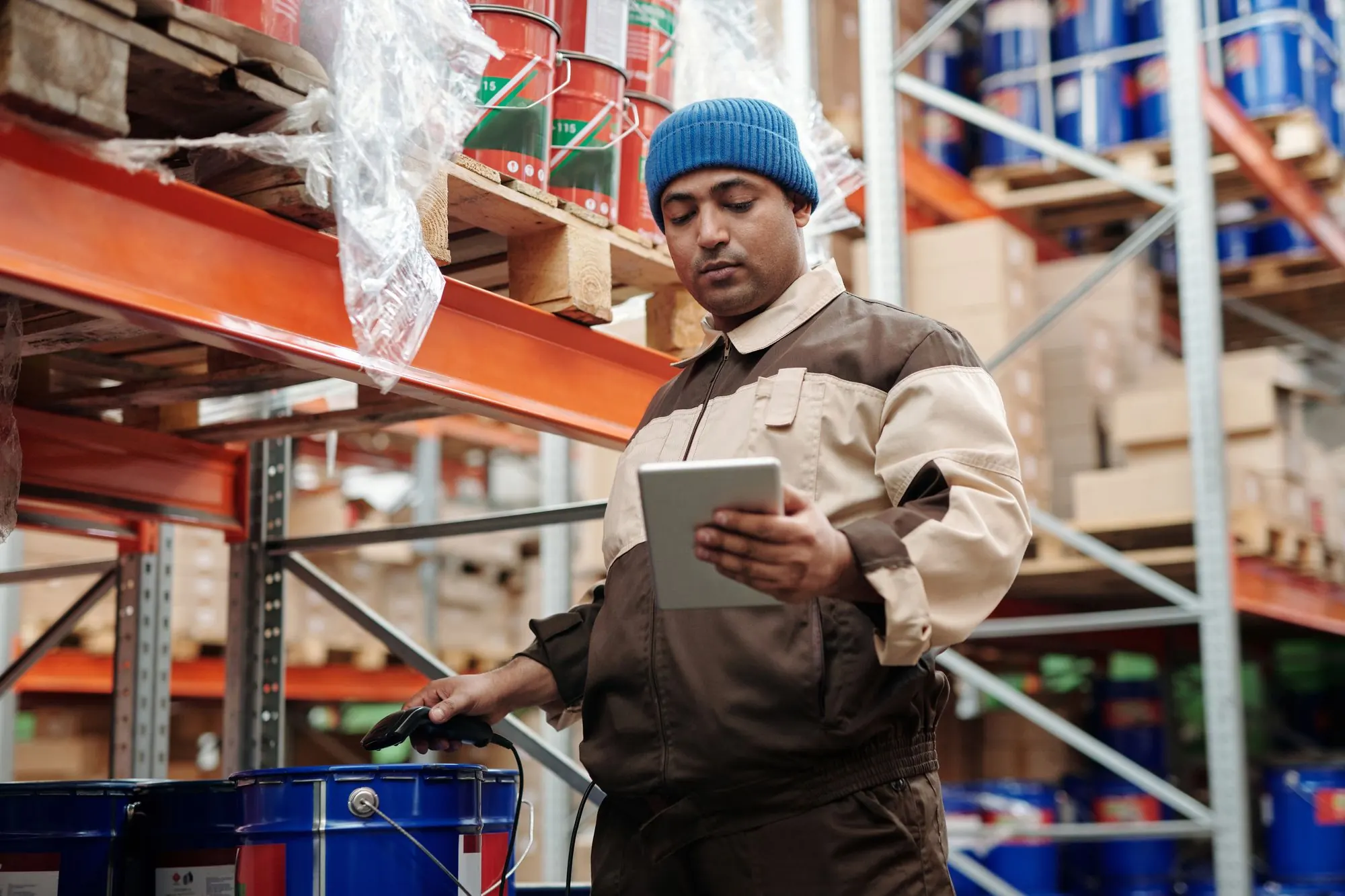 Warehouse manager checking a tablet between stocked shelves