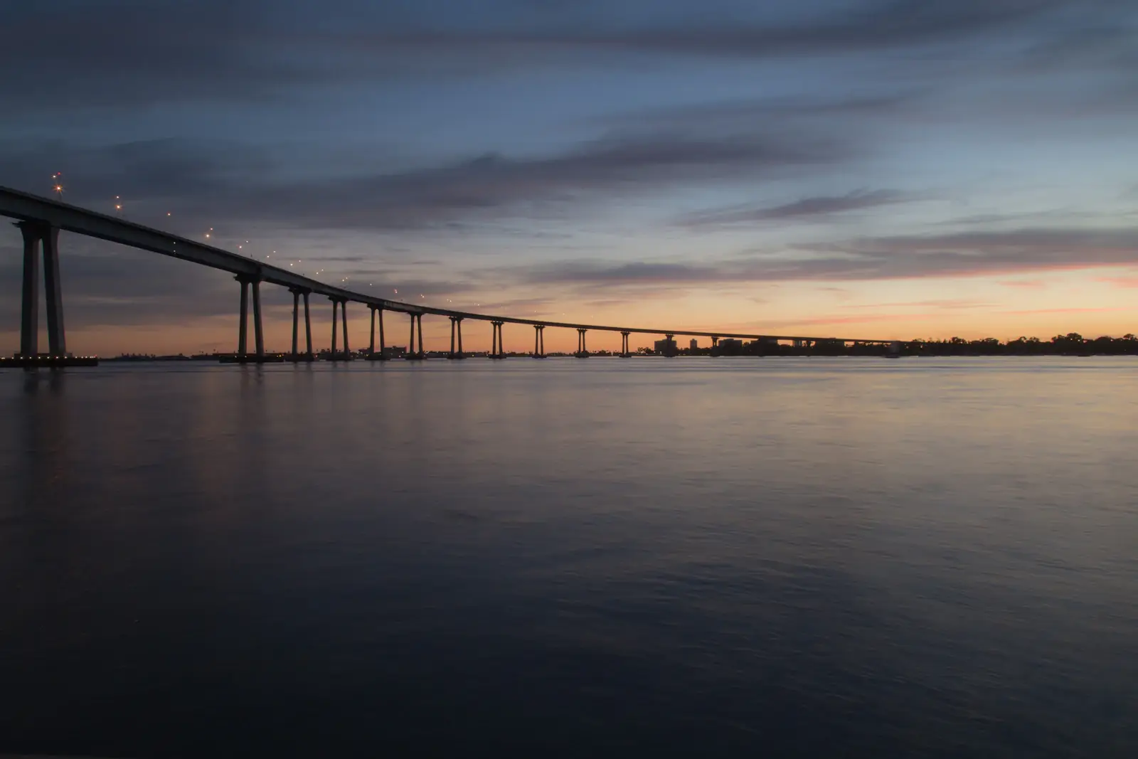 The curve of the San Diego-Coronado Bridge at dusk from Barrio Logan
