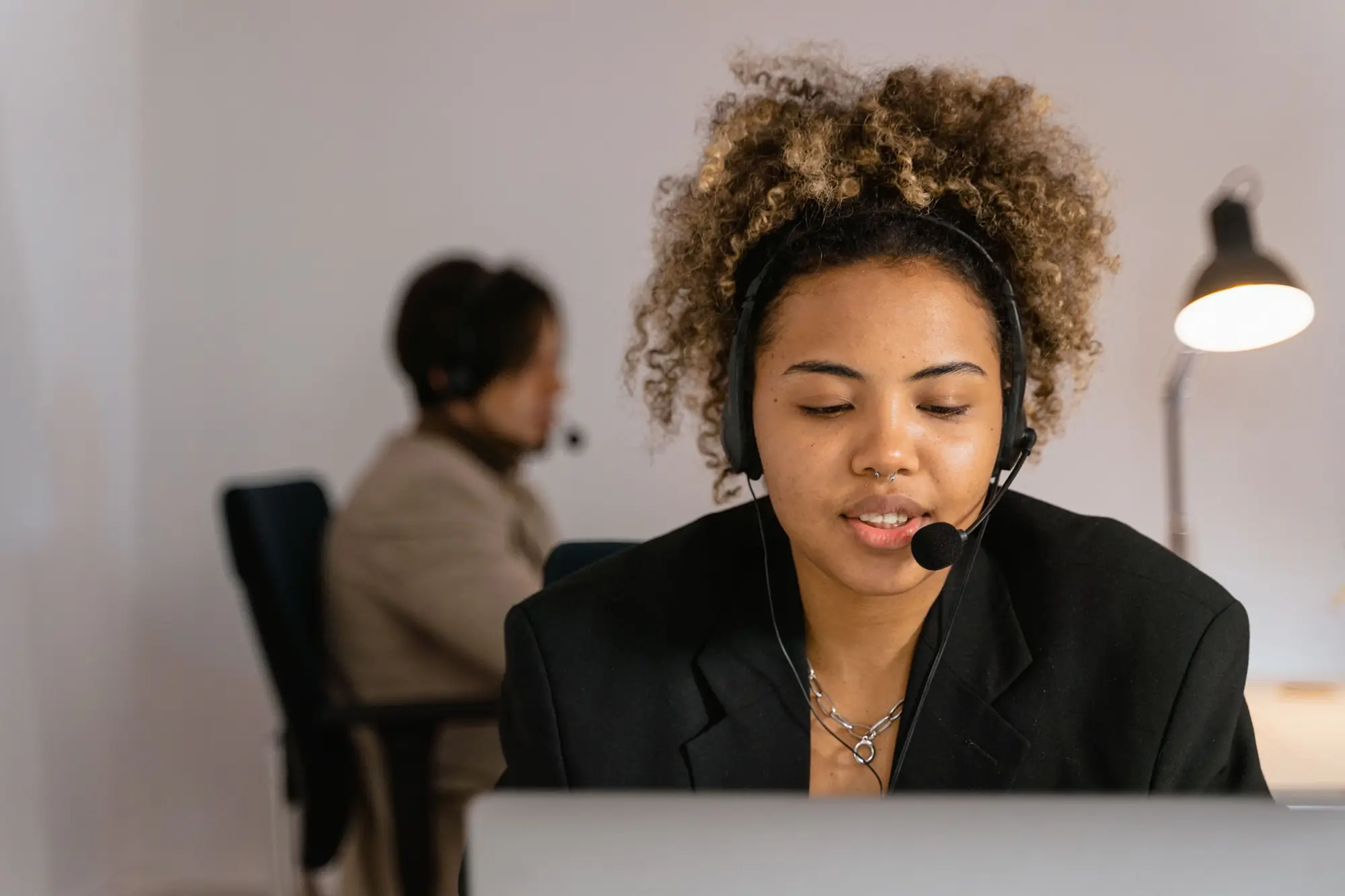 Woman on a headset talking with a prospect at her desk