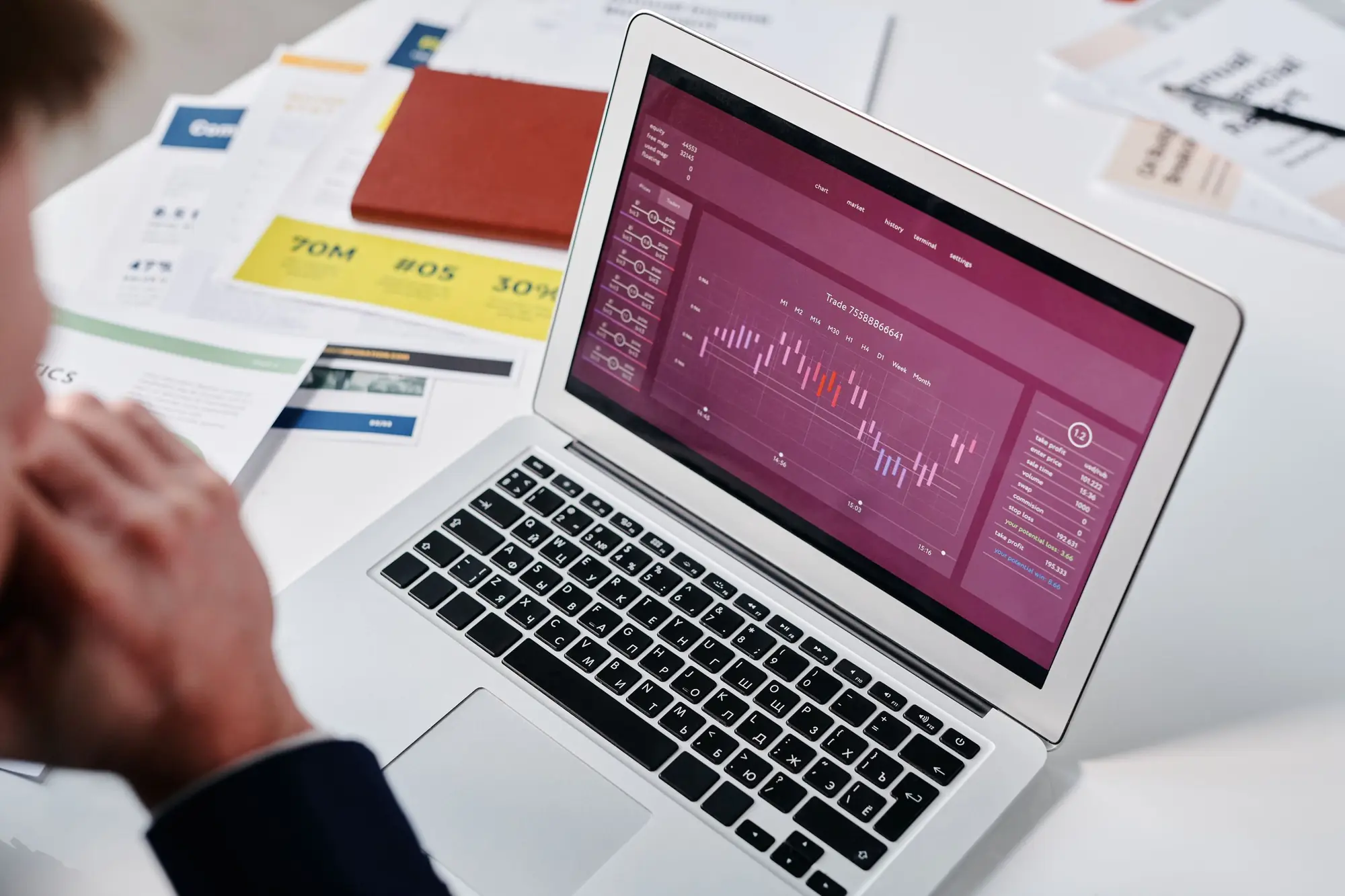 Analytics dashboard on a laptop beside printed reports